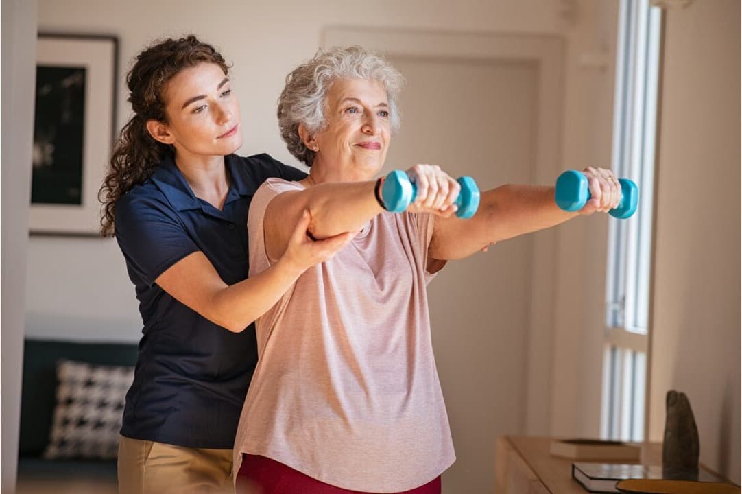 A carer and elderly woman sharing a calm, supportive moment indoors